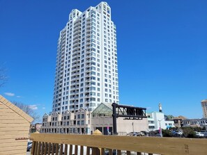 Ein hoch aufragendes, modernes Hochhaus mit mehreren Balkonen und blauem Himmel.