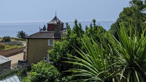 Une vue sur la côte, avec un bâtiment doté d’une tour rouge et un ciel dégagé.