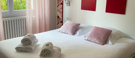 Una habitación de hotel con cama, almohadas y toallas enrolladas.