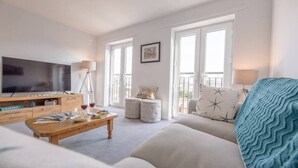 A living room with a TV, wooden coffee table, and a sofa. - Rest Ashored, Aldeburgh (Aldeburgh)