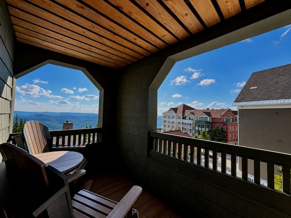 A balcony with wooden flooring and a view of a mountain range and buildings. - Highland House 302 - Ski-In/Ski-Out! (Snowshoe)