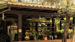 Un área de estar al aire libre con muebles de mimbre y una barra de ladrillo.