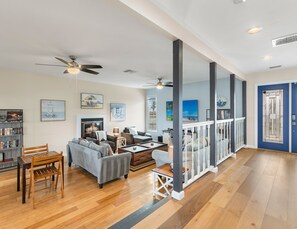 Cozy living area with a fireplace, comfortable seating, and artwork on the walls.