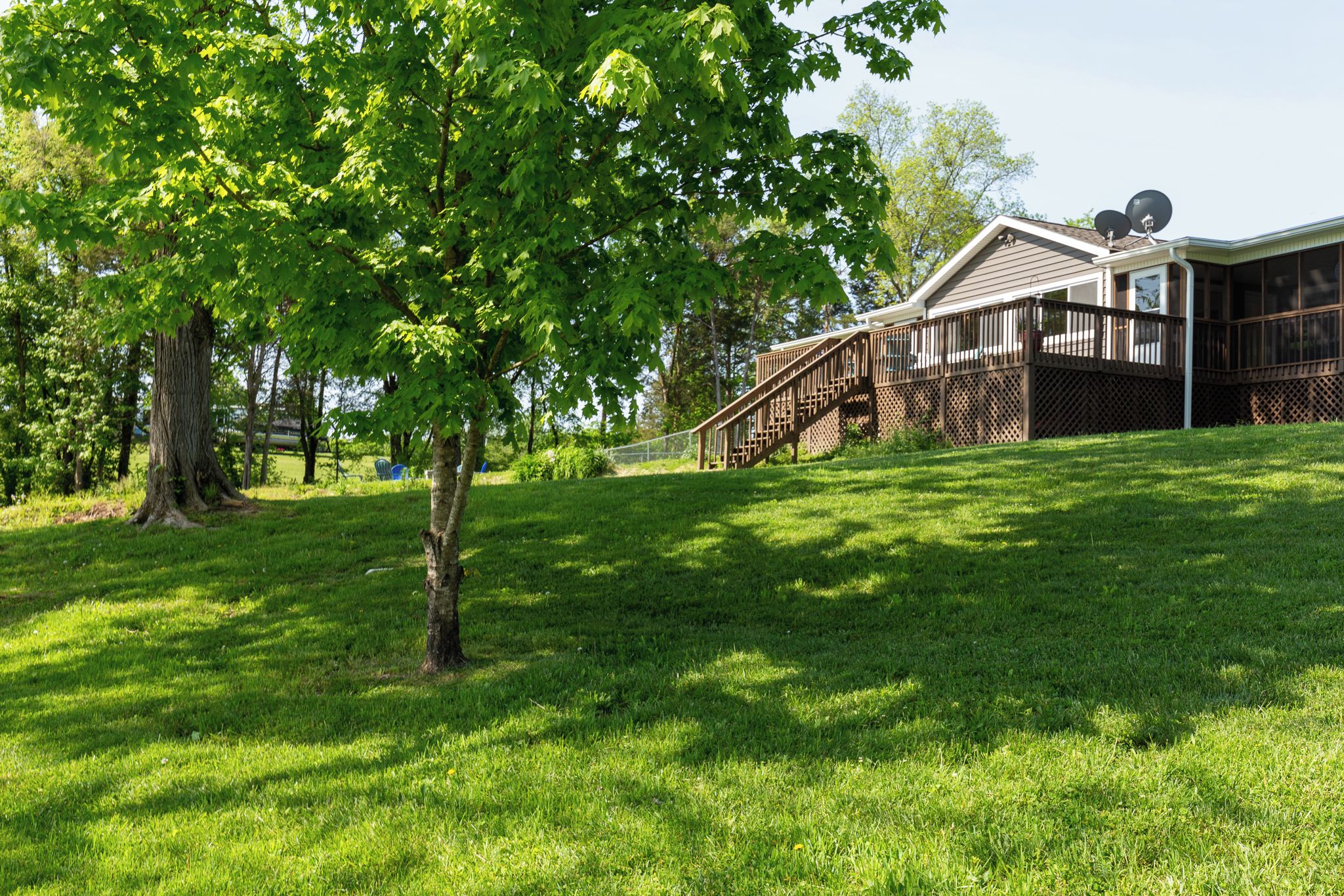 A house with a wooden deck and a staircase leading to a covered porch.
