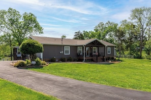 A single-story house with a front porch, a small front yard, and a driveway. - Sunrise Cove by Jackson Mountain Rentals (Dandridge)
