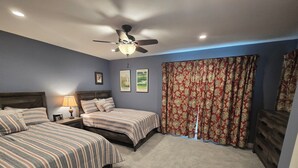 A bedroom with two beds, a ceiling fan, and a large window with patterned curtains. - Reconfigured 2 bedroom, 2 bath condo, walking distance Pinehurst Resort. (Pinehurst)