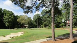 A golf course with sand bunkers, a walking path, and surrounding trees. - Reconfigured 2 bedroom, 2 bath condo, walking distance Pinehurst Resort. (Pinehurst)