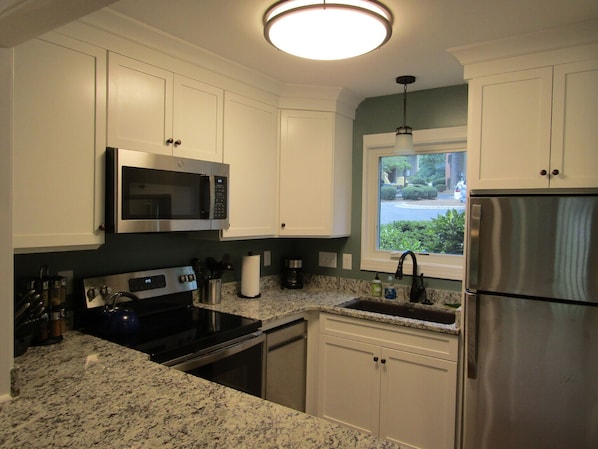 Enjoy cooking in this well-equipped kitchen with a microwave, stove, dishwasher, and refrigerator.