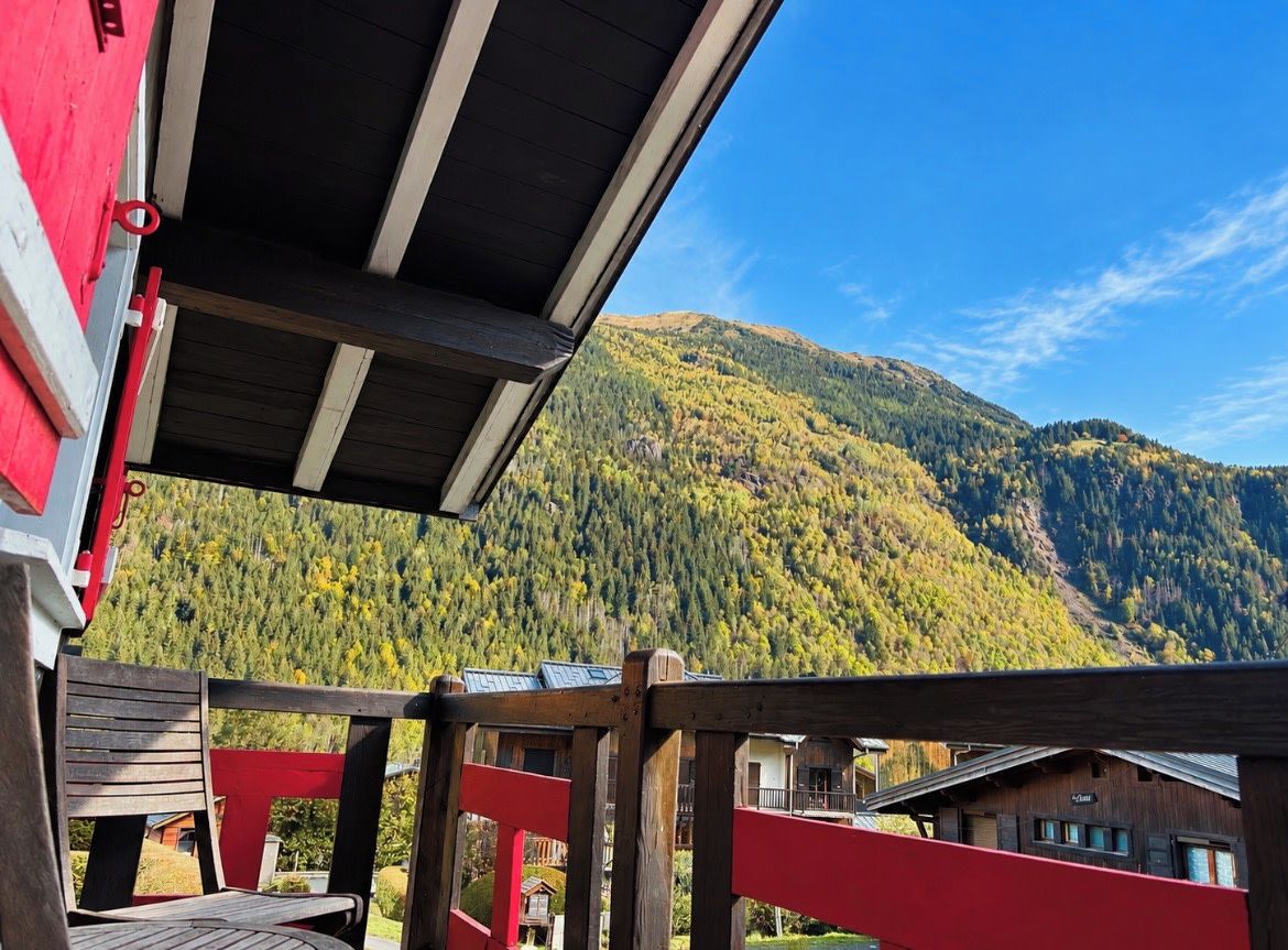 A wooden deck with a view of a mountain.
