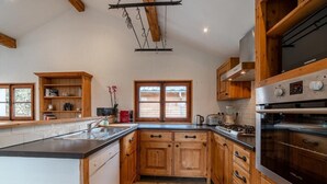 Een keuken met houten kastjes, een roestvrijstalen afzuigkap en een grote oven.