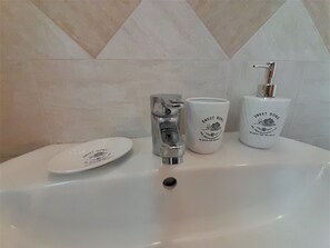 A bathroom sink with a chrome faucet, a soap dispenser, and a plate with text. - Accommodation in the heart of Monferrato, an Unesco heritage site (Calliano)