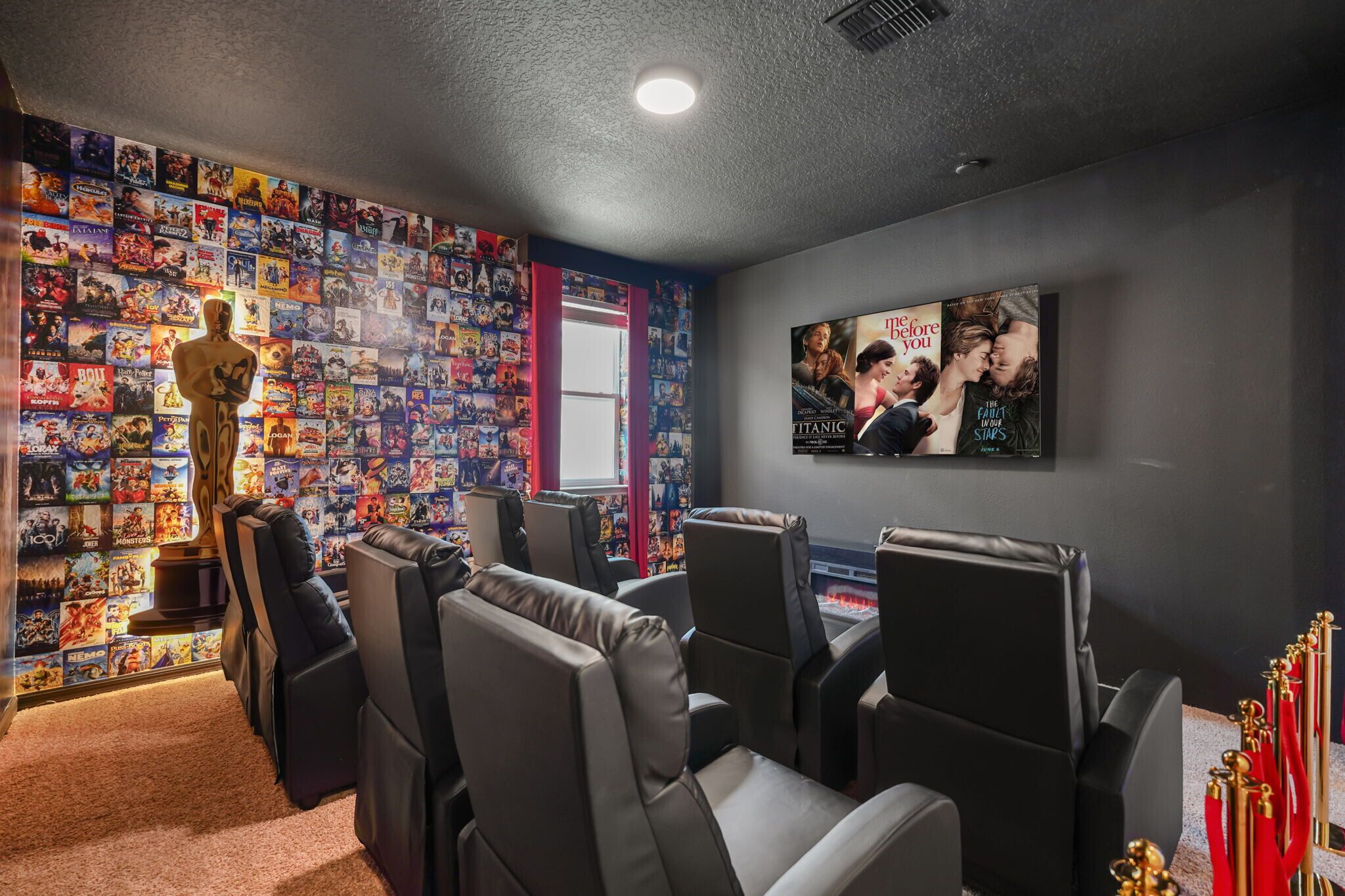 Une chambre sur le thème du cinéma, avec un mur recouvert d’affiches de films, une grande statuette d’Oscar et une affiche de film accrochée au mur.