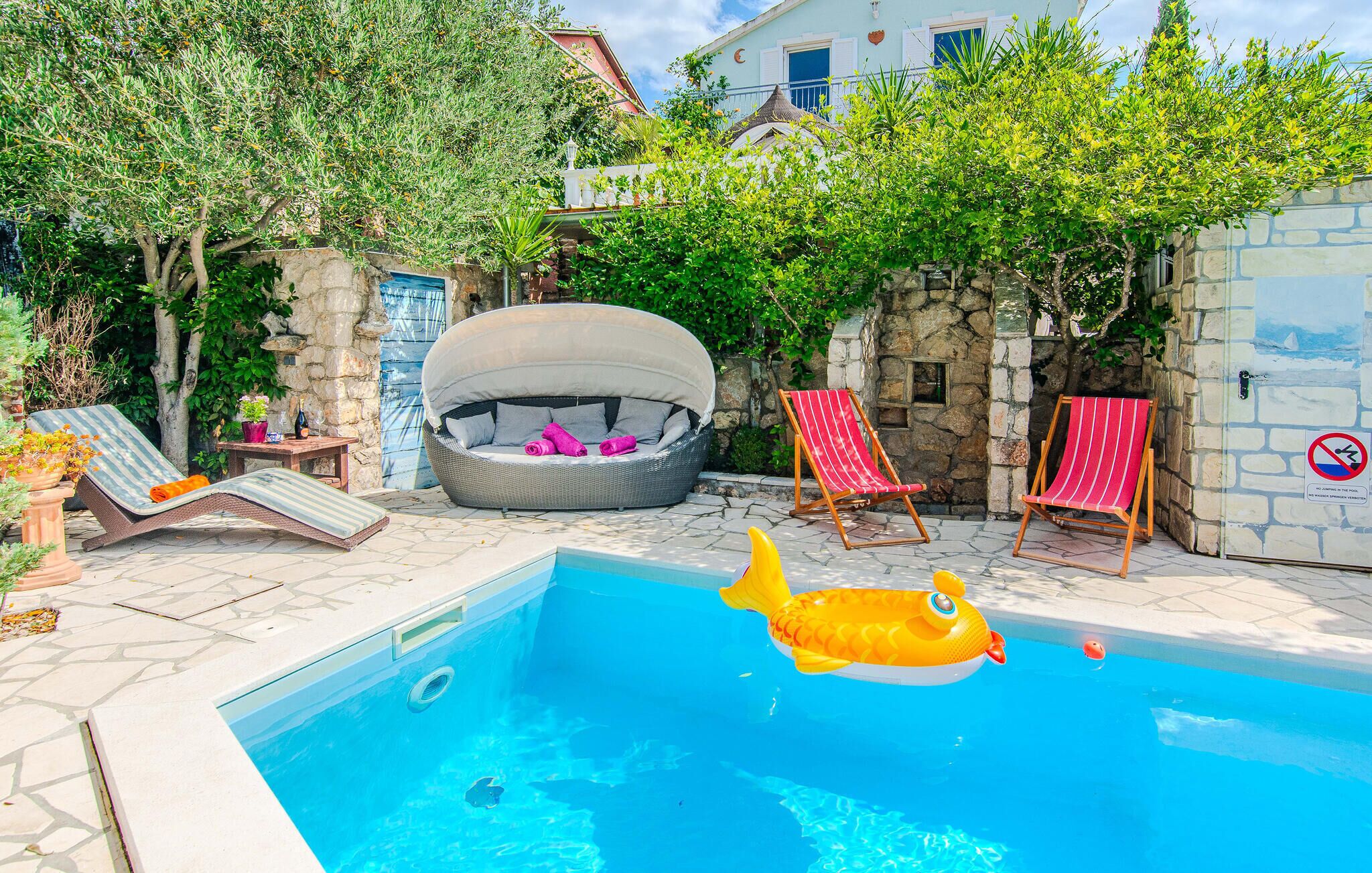 A swimming pool with lounge chairs and a hot tub.