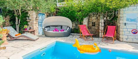A swimming pool with lounge chairs and a hot tub.