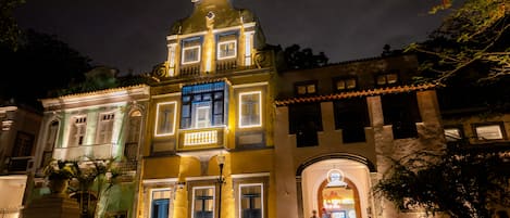 Un edificio histórico con un balcón central y entrada a una tienda.
