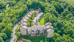 An aerial view of a resort with multiple buildings, a swimming pool, and a road.