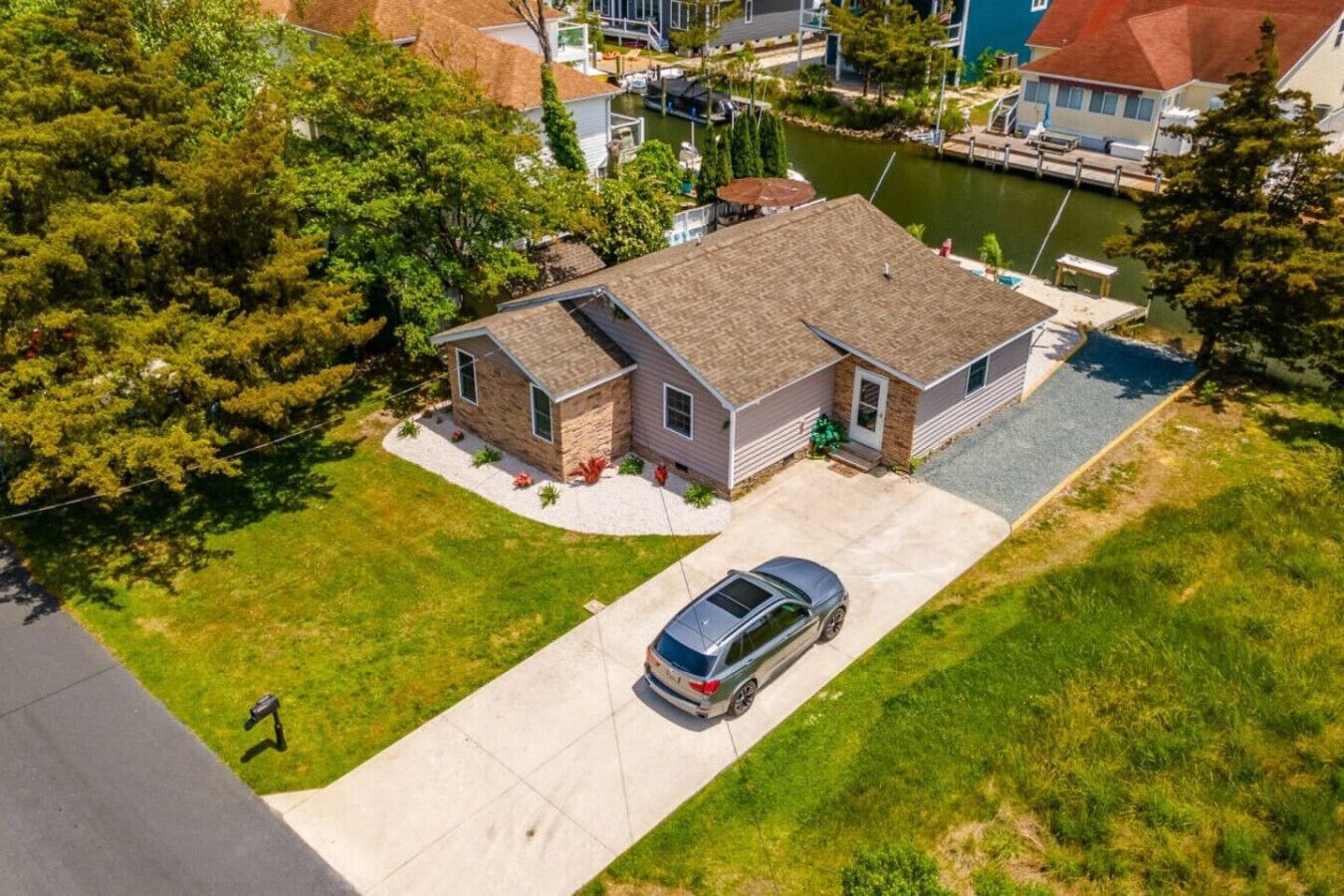 A single-story house with a garage, a driveway, and a small lawn.