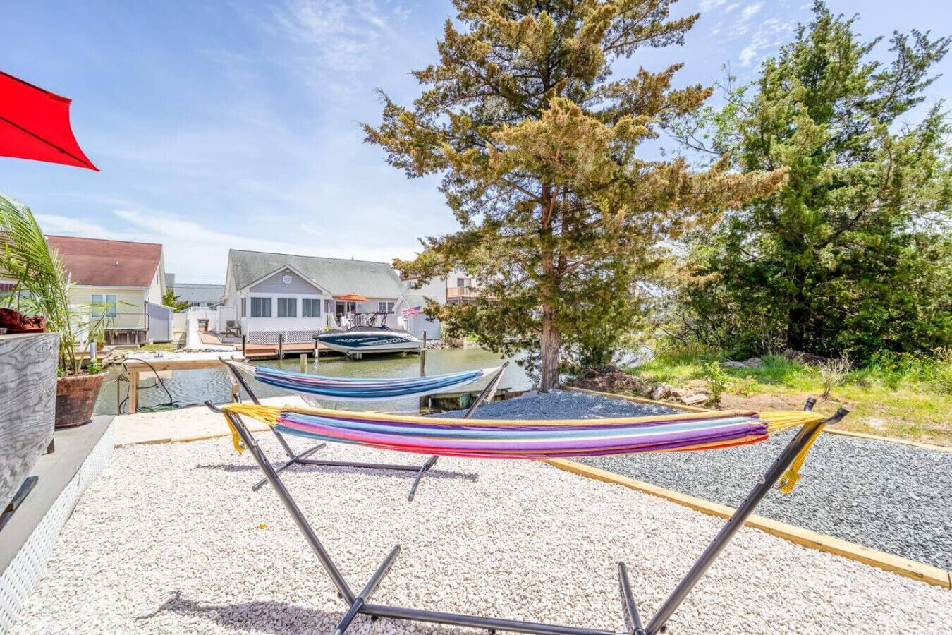 Una proprietà sul lungomare con un molo, un'amaca e una casa sullo sfondo.