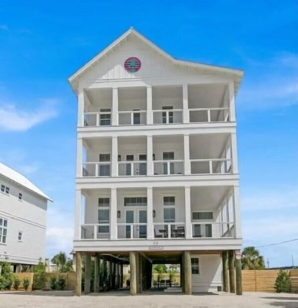 Un immeuble à plusieurs étages doté d’une entrée centrale et de balcons à chaque niveau.