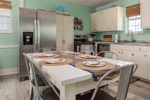 A kitchen with a stainless steel refrigerator, white cabinets, a built-in oven, and a sink. - Close to the beach! Water view, pet friendly! - Nautical Nonsense (Dauphin Island)