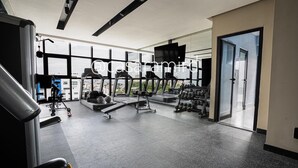 Un gimnasio moderno con cintas de correr, bancos de pesas y mancuernas.