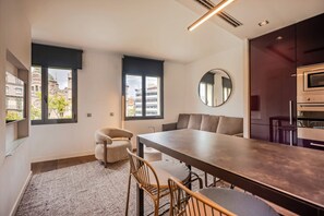 A modern kitchen with a built-in oven and a dining area with a long table and chairs.