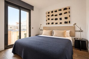 A bedroom with a large bed, a headboard, a nightstand, a floor lamp, and a wall-mounted artwork. - Sweett | Palau 601 - One Bedroom Apartment, Sleeps 3 (Barcelona)
