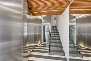 A modern interior with a staircase, metallic walls, and a wooden ceiling. - Sweett | Palau 602 - One Bedroom Apartment, Sleeps 3 (Barcelona)