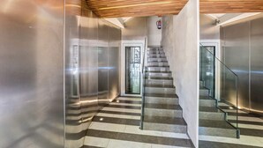 A modern interior with a staircase, metallic walls, and a wooden ceiling. - Sweett | Palau 602 - One Bedroom Apartment, Sleeps 3 (Barcelona)