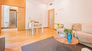 Un salon moderne comprenant un canapé, une table basse et un coin repas avec une table et des chaises.