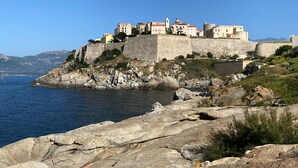 Eine Küstenstadt mit historischen Gebäuden, die auf einem steilen Felsen über dem Meer thront.