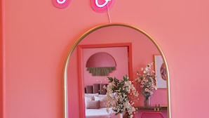 A pink room with a neon sign reading "Hello Gorgeous," a round mirror, and a vase with flowers. - 🍷🌇  All Day & Night!  BEST EAST NASH location - Walkable (Nashville)