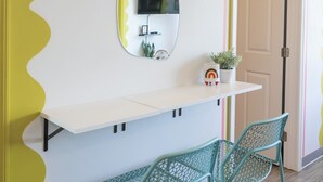 A room with a white wall, a large mirror, a white shelf with a small plant, and two green chairs. - 🎸🎇 CLUELESS HOME IN NASH-VEGAS! WALKABLE LOCATION! (Nashville)
