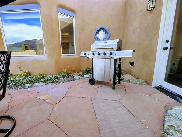 A patio with a barbecue grill, a window, and a door. - Casa del Gavilan panoramic view patio hot tub wireless wifi fireplace (El Prado)