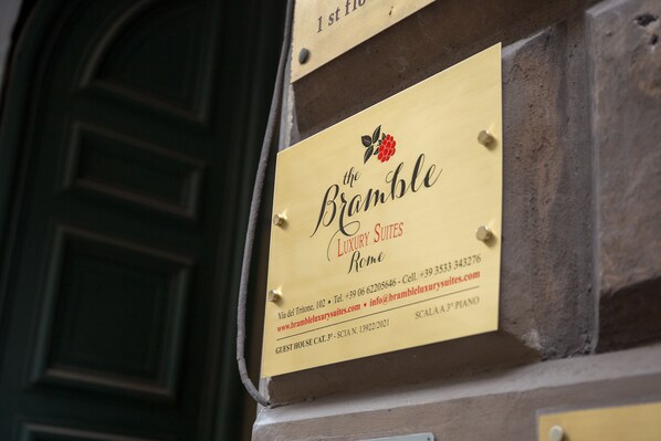 A sign for "The Bramble Luxury Suites Rome" with contact information and a website URL. - Bramble Luxury Suites (Rome)