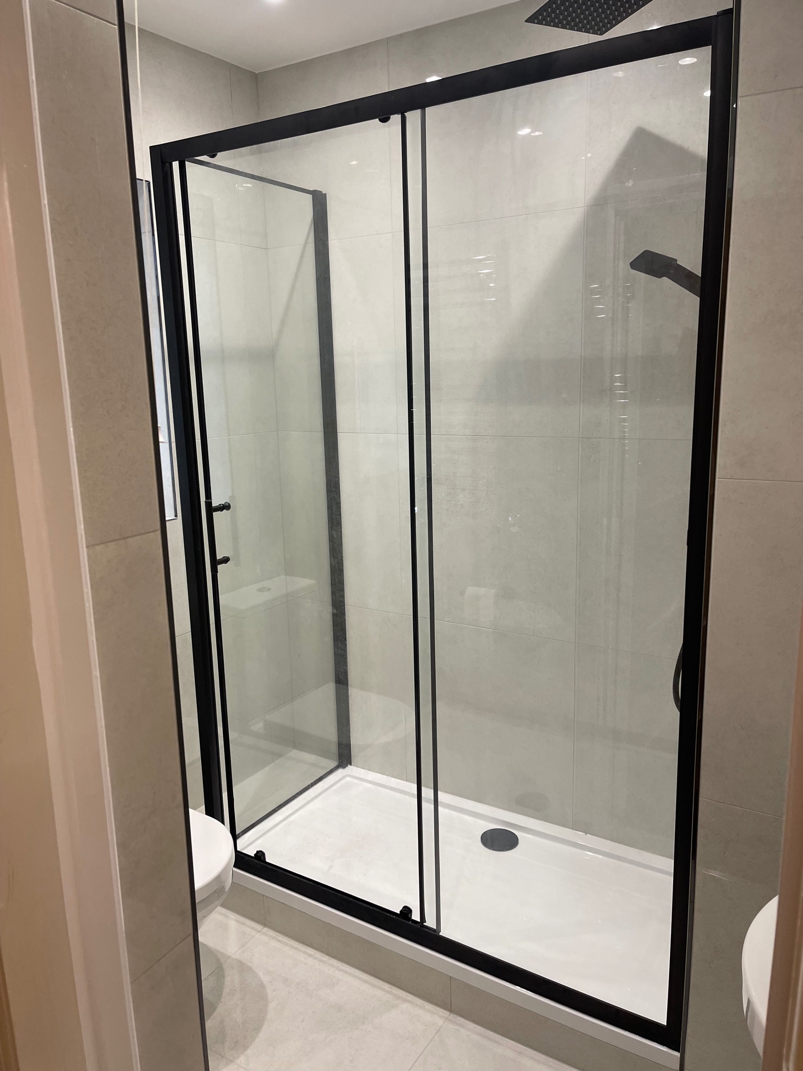 Um banheiro moderno com chuveiro em gabinete de vidro, vaso sanitário branco e banheira.