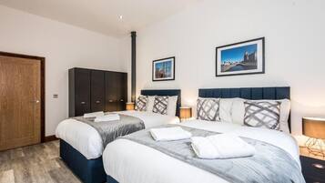 Une chambre d’hôtel avec deux lits, une armoire et deux tableaux encadrés au mur.