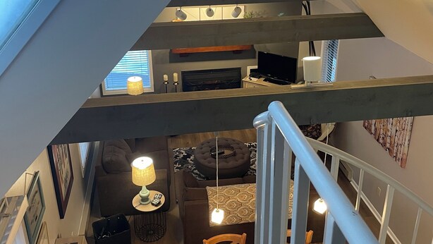 Um interior com vários níveis, incluindo sala de jantar, escada e área de estar.