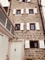 Un edificio de varios pisos de piedra con varias ventanas y un portón de garaje.