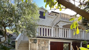 A stone staircase leading to a stone building with a balcony.