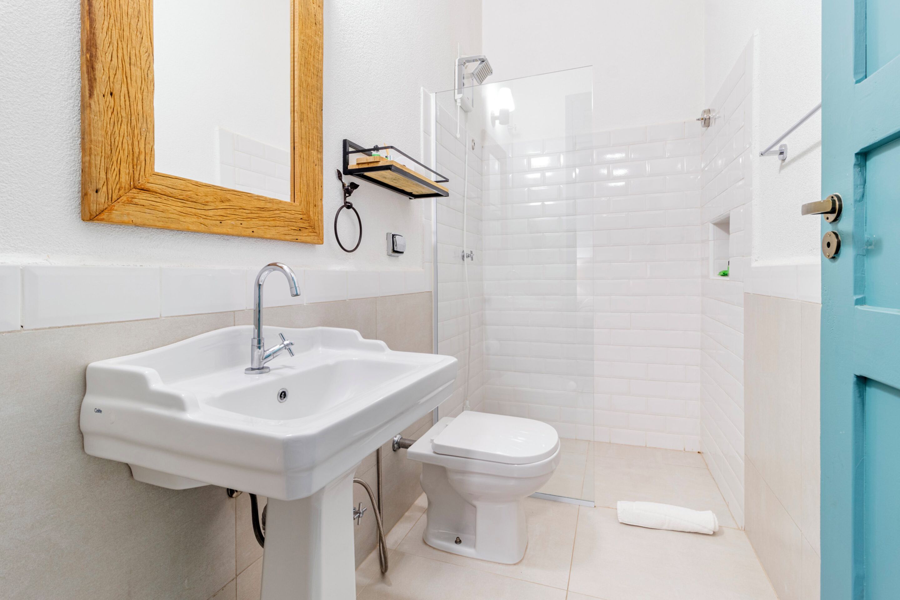 A bathroom with a white sink, a toilet, and a shower area.