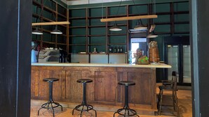 A bar area with wooden stools, a counter, and hanging lights.