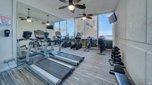 A gym with treadmills, exercise bikes, and free weights.