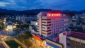 Un hotel de varios pisos con un llamativo letrero rojo en la parte superior.
