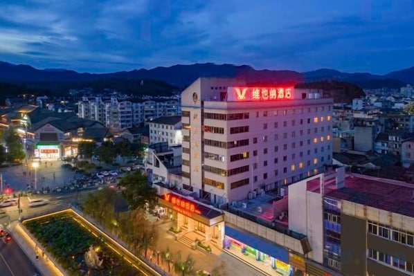 A multi-story hotel with a prominent red sign on the top. - Vienna Hotel lishui Longquan (Longquan)