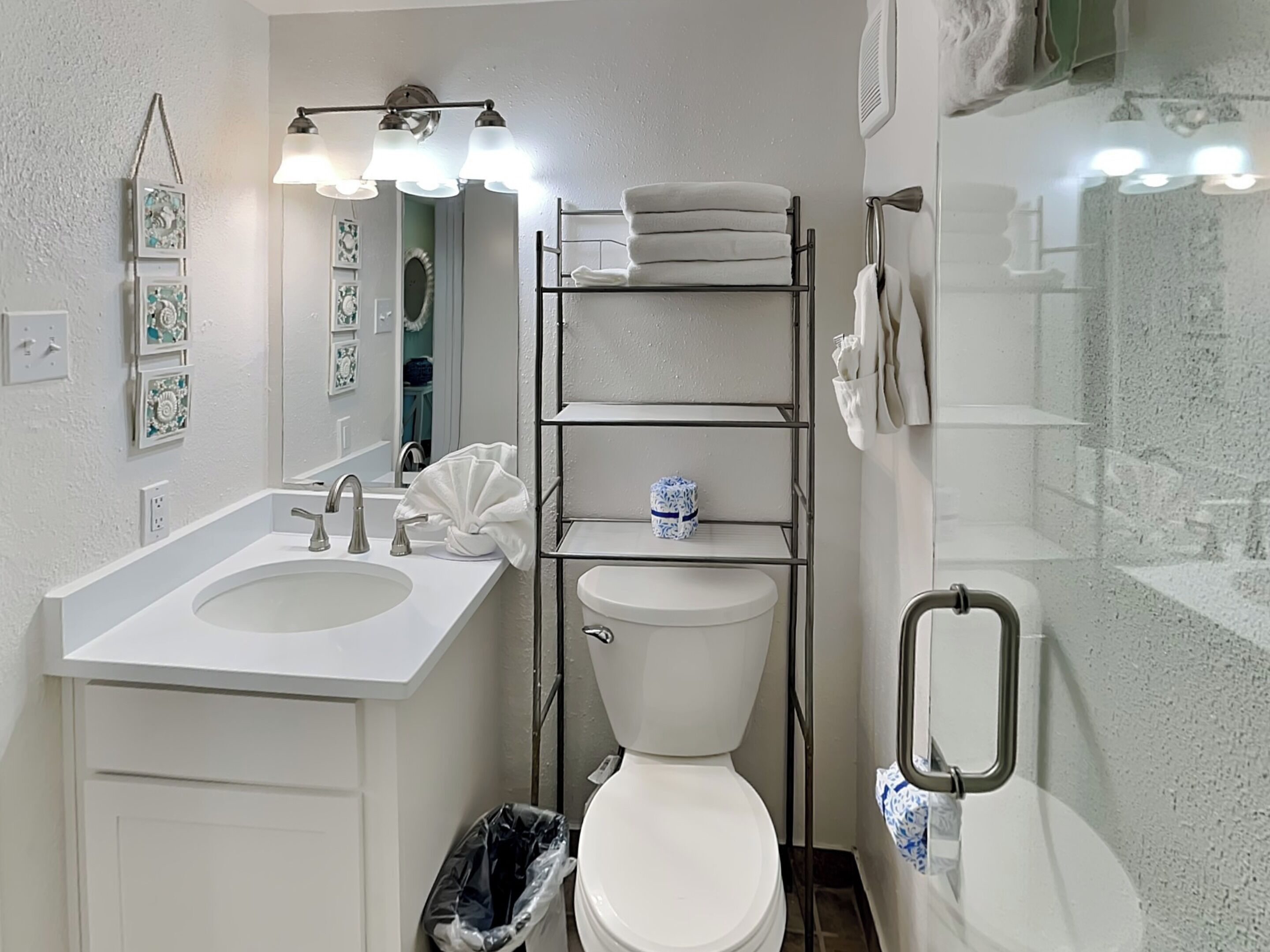 A bathroom with a white sink, a toilet, a mirror, and a towel rack.