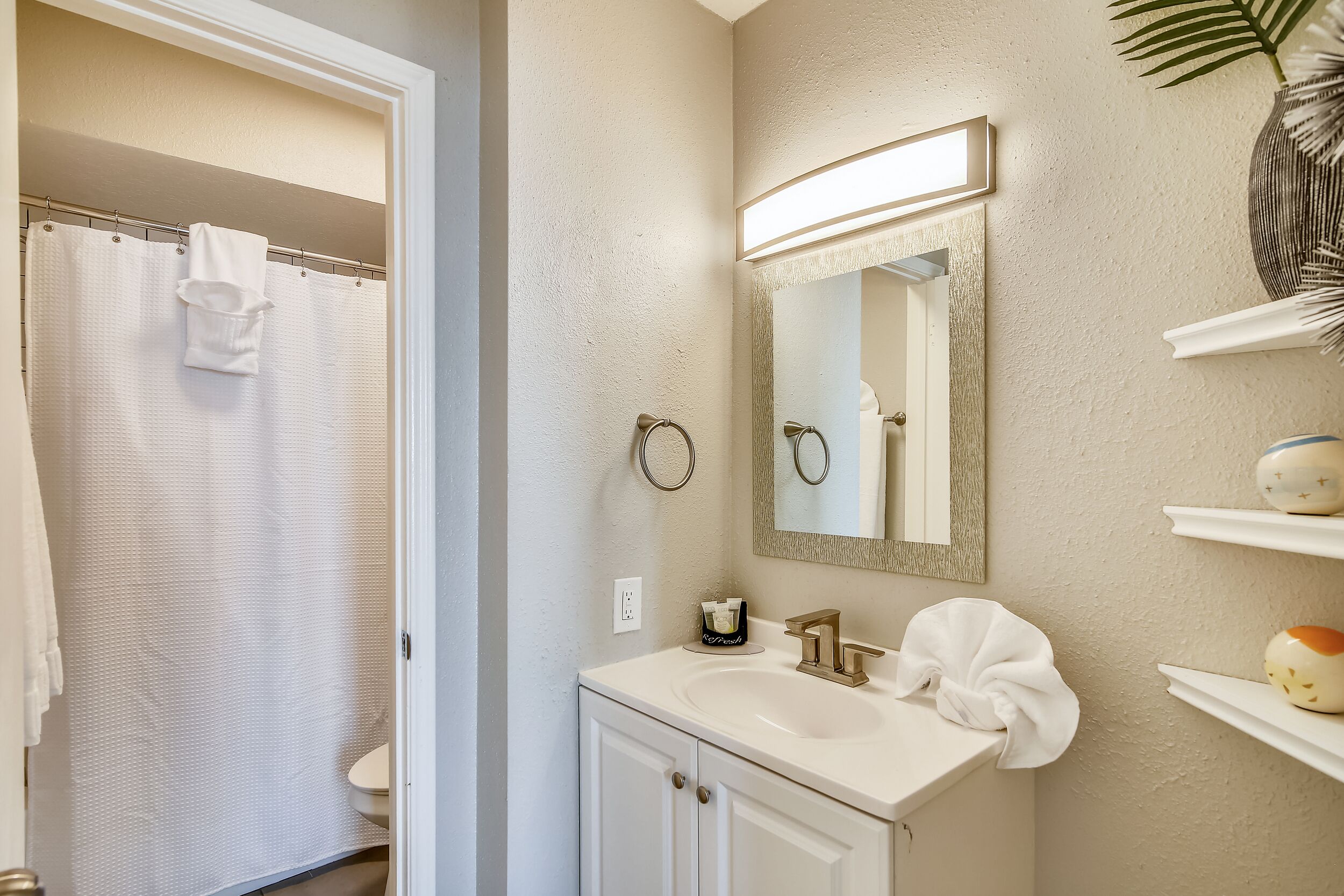 A bathroom with a white sink, a mirror, and a towel rack.