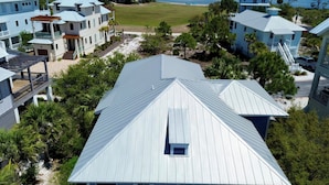 Uma área residencial costeira com várias casas, uma praia e um cais.