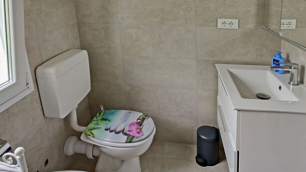 A bathroom with a toilet, sink, and a trash bin. - Charmantes Landhaus mit Pool und Großer Terrasse (Tavole/ Prela)