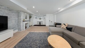 Una sala de estar moderna con chimenea, un sofá, una mesa de centro y un televisor.